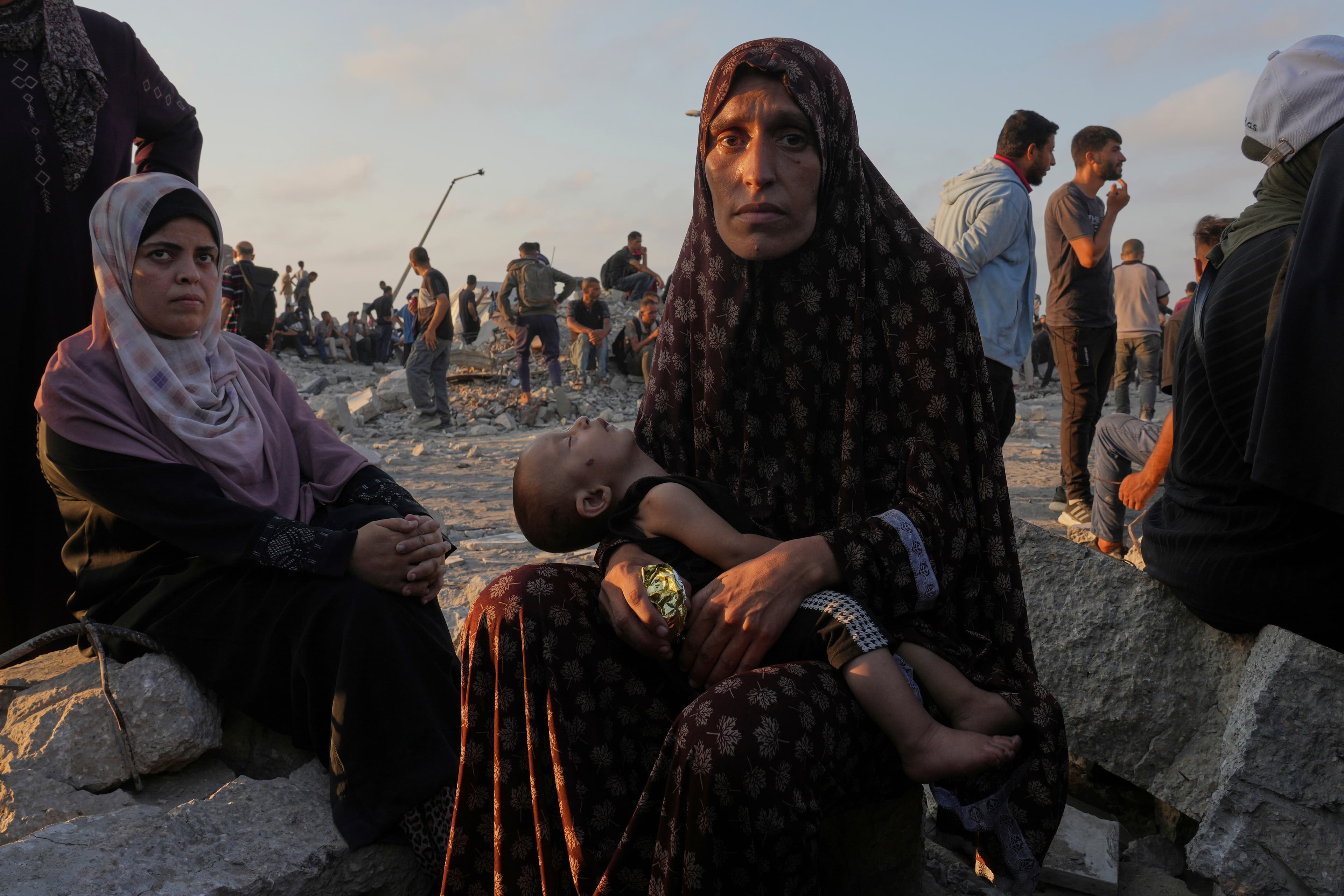 Palestínska žena Somoud Wahdan v Gaze čaká so svojim dieťaťom na humanitárnu pomoc. Foto: TASR/AP
