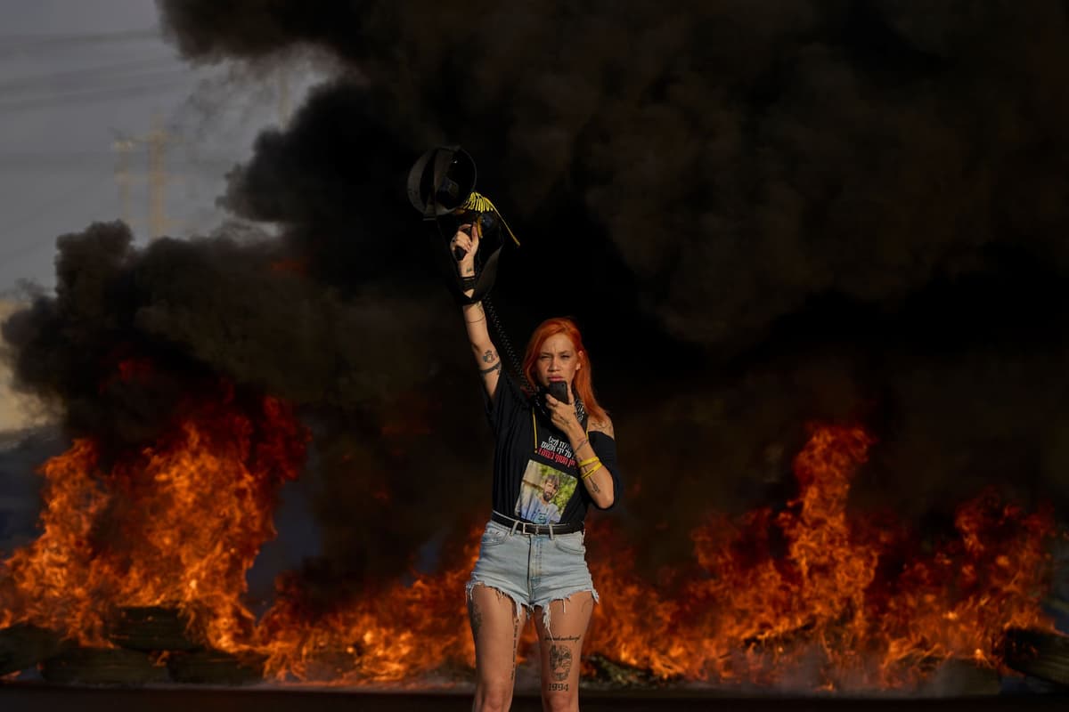 Aktivistka, ktorá požaduje prepustenie rukojemníkom Hamasom a zastavenie plánov na anexiu Pásma Gazy blokuje diaľnicu pri izraelskom meste Lod 26. augusta 2025. Foto: TASR/AP