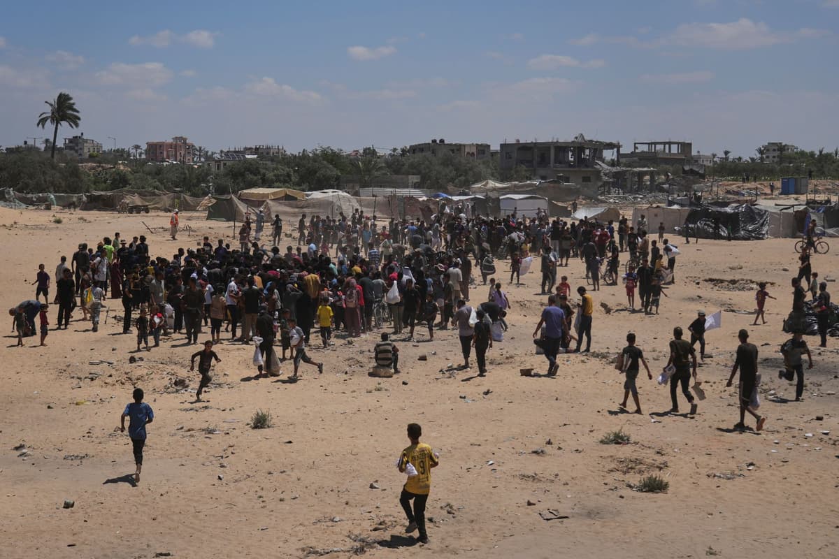 Palestínčania sa ponáhľajú zbierať humanitárnu pomoc zhodenú z lietadiel na padákoch do Dajr al-Balah 5. augusta 2025. Foto: TASR/AP