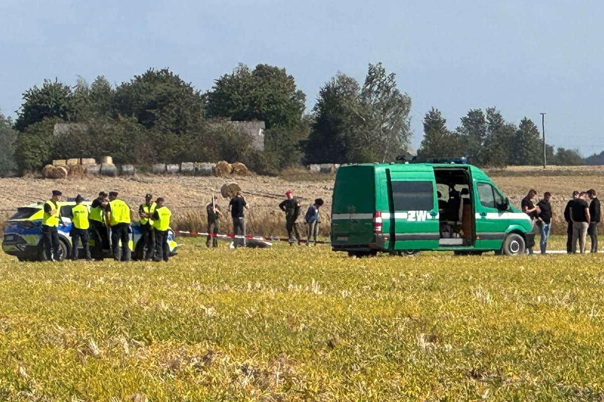 Policajti a príslušníci vojenskej polície zabezpečujú časť úlomkov jedného z dronov. FOTO: TASR/AP Photo/Rafal Niedzielski
