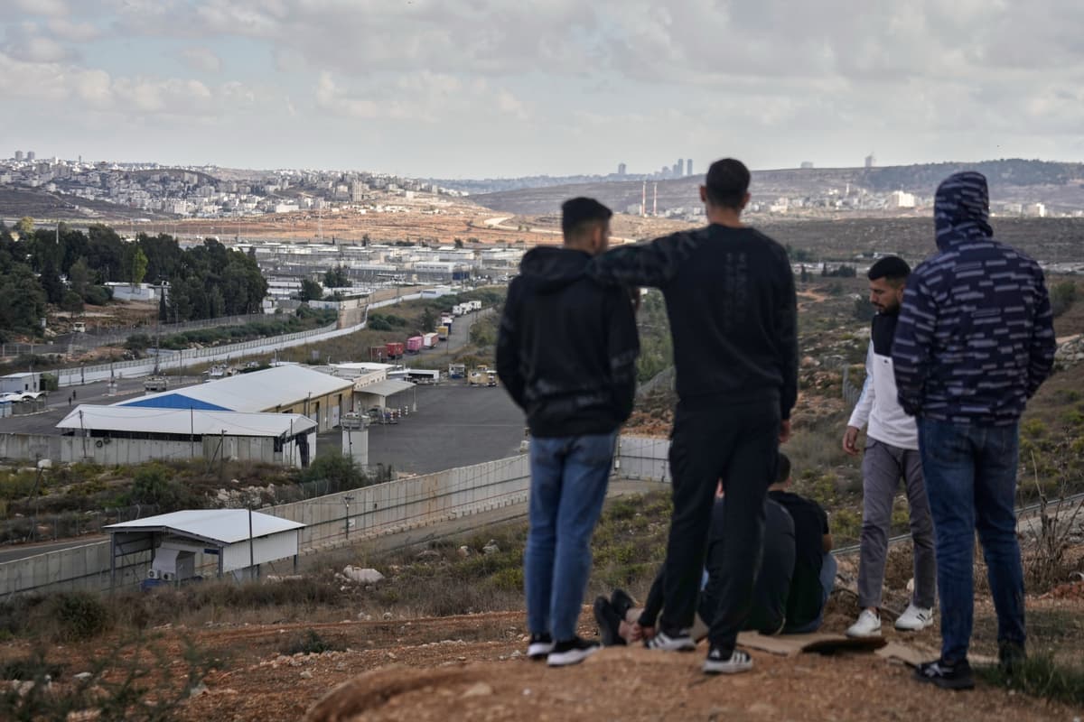 Palestínčania sa pozerajú na izraelskú väznicu, kde čakajú na prepustenie palestínskych väzňov ako súčasť výmeny za izraelských rukojenmíkov. Foto: TASR/AP