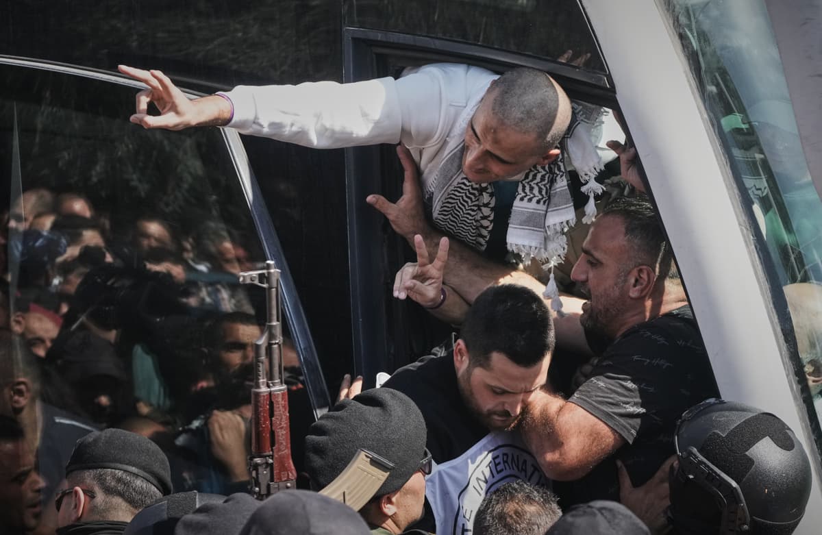 Palestínski väzni mávajú z autobusu po prepustení z izraelského väzenia v Ramalláhu na západnom brehu Jordánu. Foto: TASR/AP