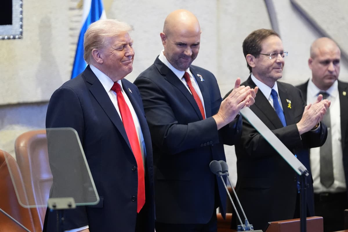 Donald Trump, predseda izraelského parlamentu Amir Ohana a izraelský prezident Jicchak Herzog tlieskajú na počesť Trumpa pred jeho prejavom v Knesete v Jeruzaleme. Foto TASR/AP