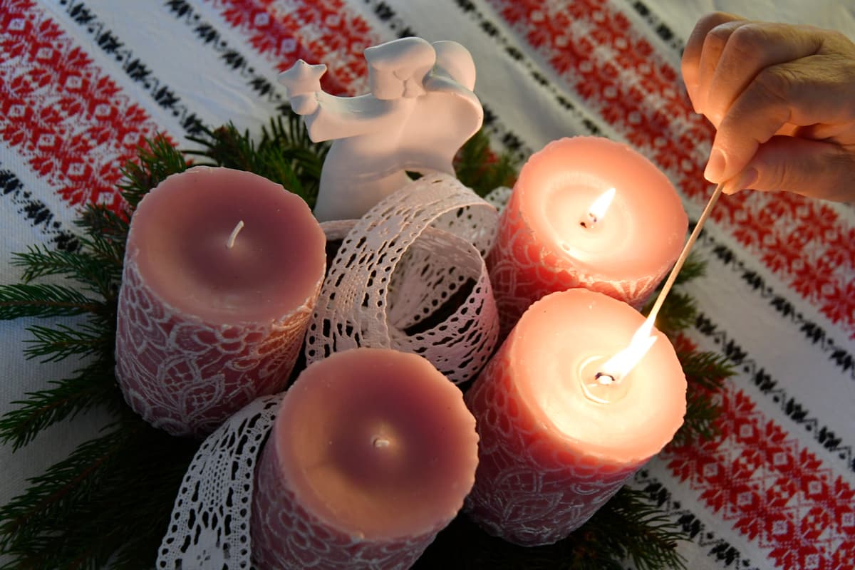 Chlapec zapaľuje druhú sviečku na adventnom venci. Foto: Martin Palkovič/TASR