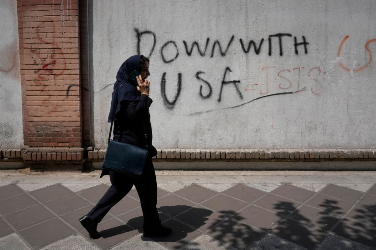 Žena prechádza popri protiamerickom graffiti na stene britského veľvyslanectva v Teheráne v Iráne 27. júla 2026. Foto: TASR/AP