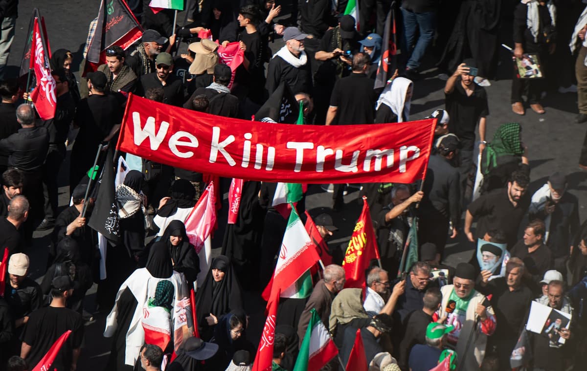 „Zabijeme Trumpa“, píše sa na transparente, ktorý nesú ľudia v sprievode počas pohrebu Alího Chameneího. Foto Behnam Tofighi / UPI / Profimedia