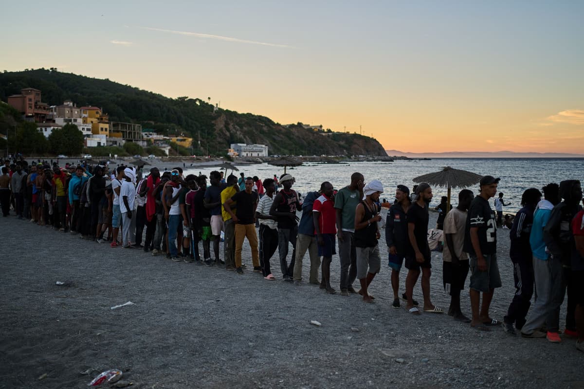 Migranti v Ceute čakajú v rade na rozdávanie jedla na pláži v pondelok 3. augusta 2026. Foto: TASR/AP