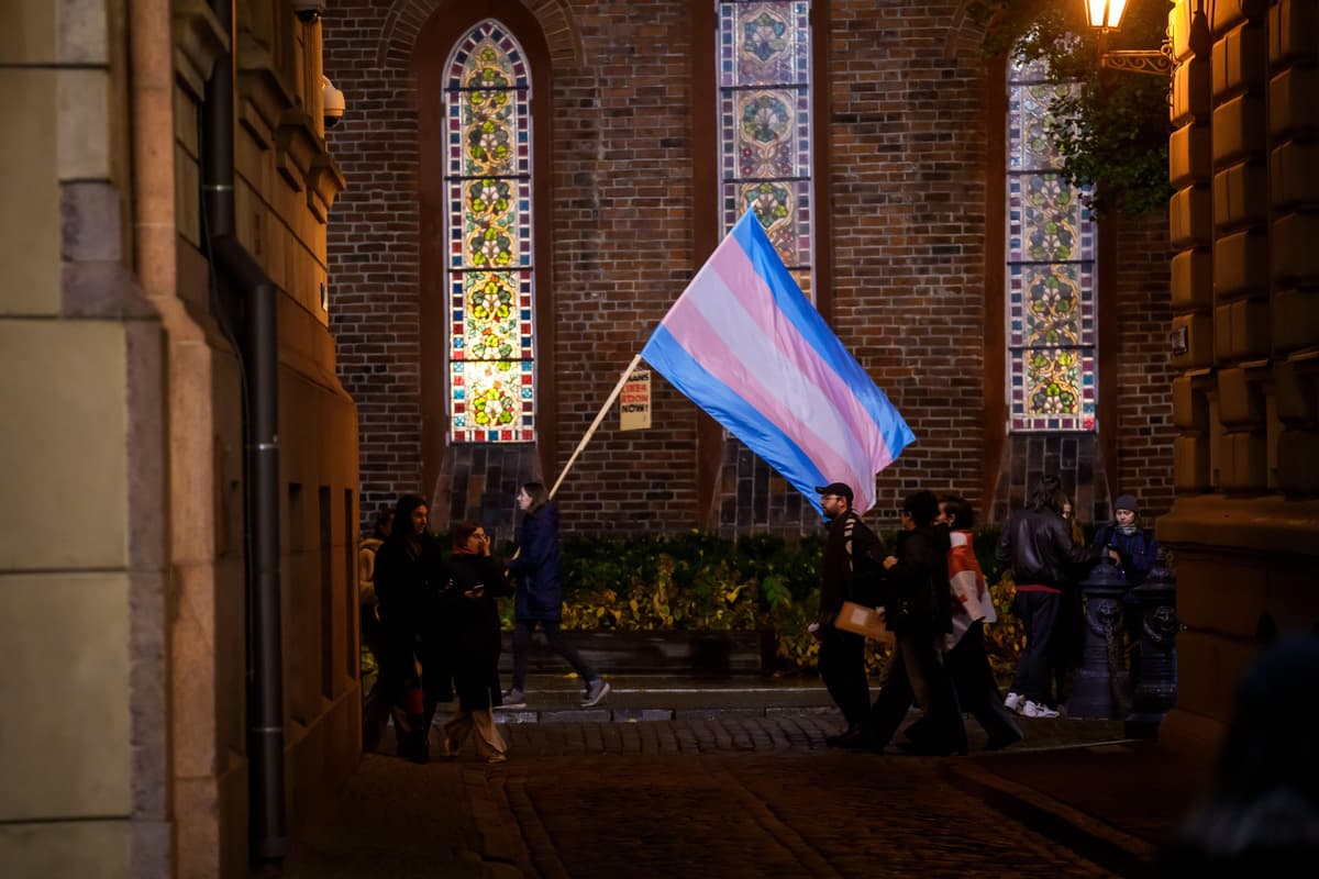 Osoba s vlajkou na podporu trans komunity počas protestu proti odstúpeniu od Istanbulského dohovoru v Lotyšsku v blízkosti parlamentu 29. októbra 2025. Foto: Gints Ivuskans / Alamy / Profimedia