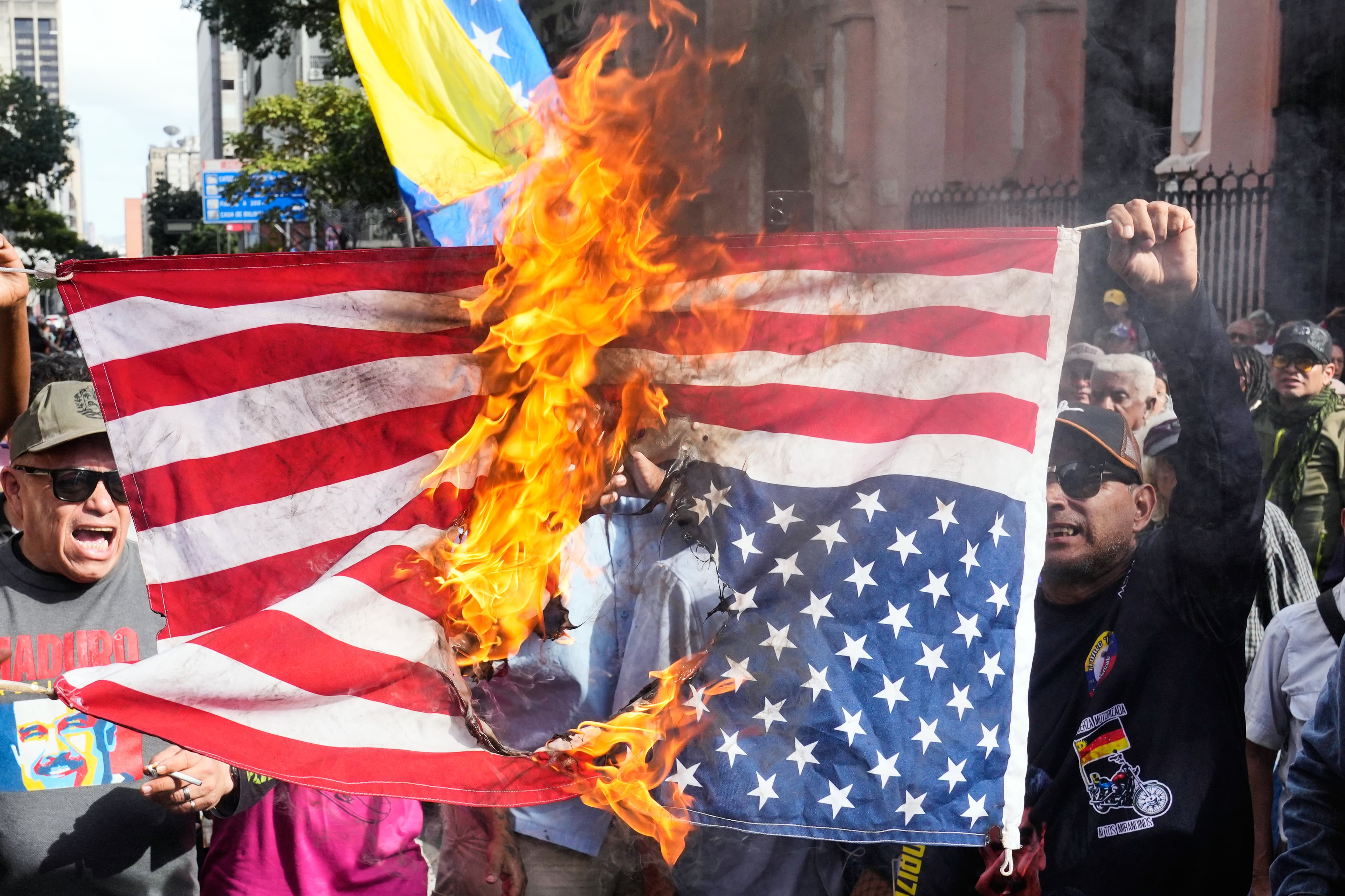 Demonštranti vo Venezuele pália americkú vlajku. Foto: TASR/AP.