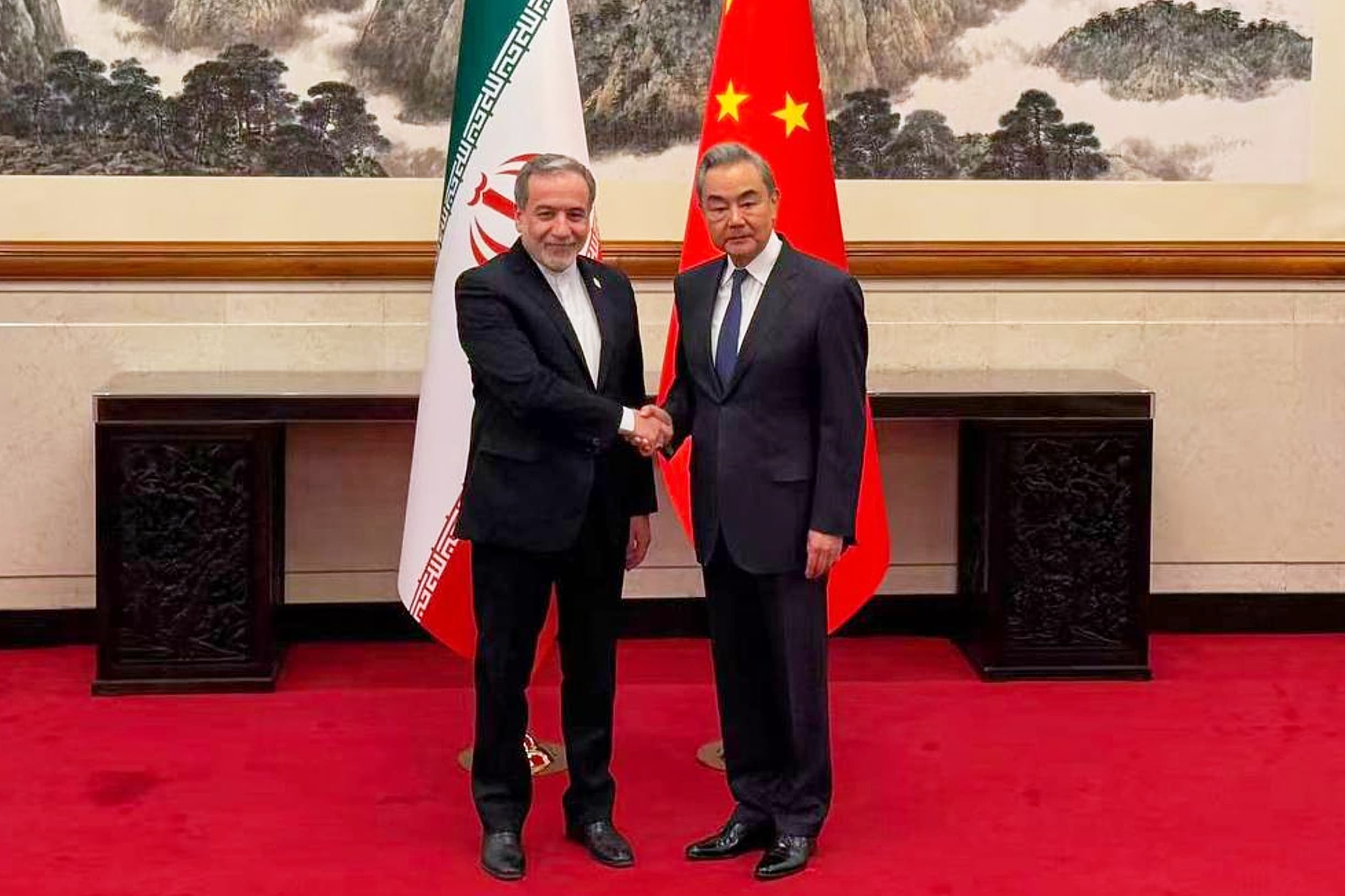 Iránsky minister zahraničných vecí Abbás Arákčí (vľavo) si podáva ruku so svojím čínskym rezortným partnerom Wangom I počas ich stretnutia v Pekingu 6. mája 2026. Foto: TASR/AP